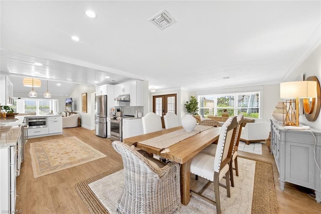 Spacious dining area featuring wood-finish flooring and recessed lighting