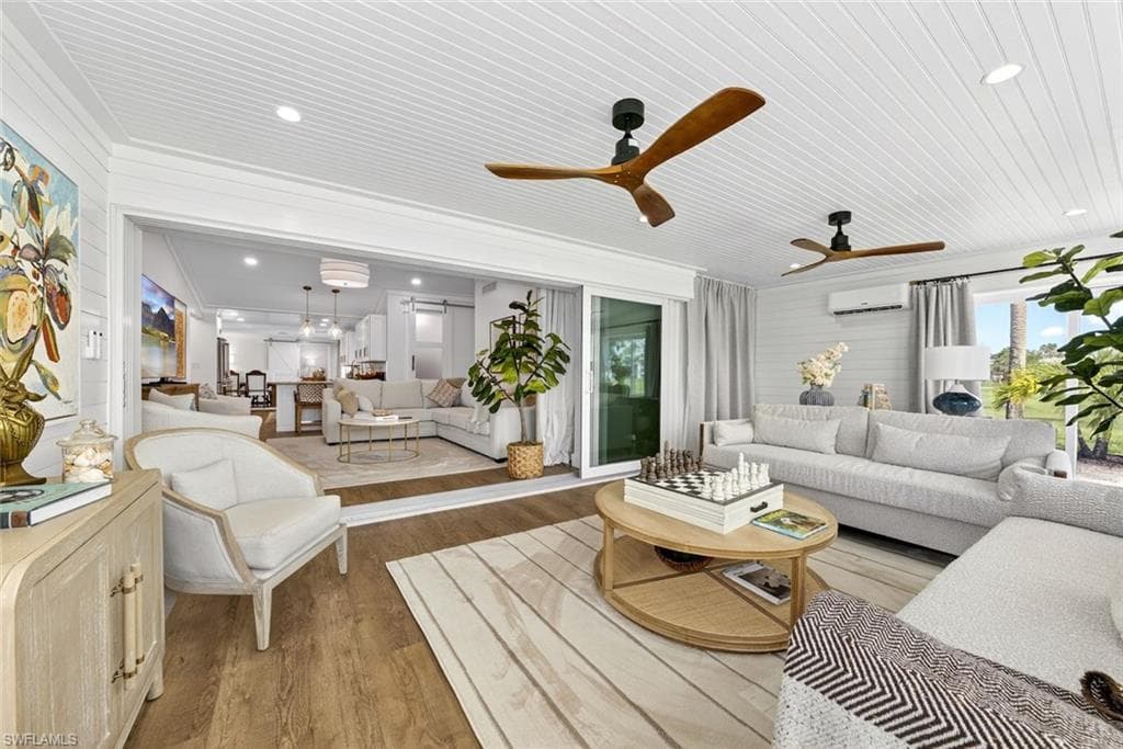 Spacious living area featuring light wood-finish flooring, white shiplap walls, and a matching shiplap ceiling