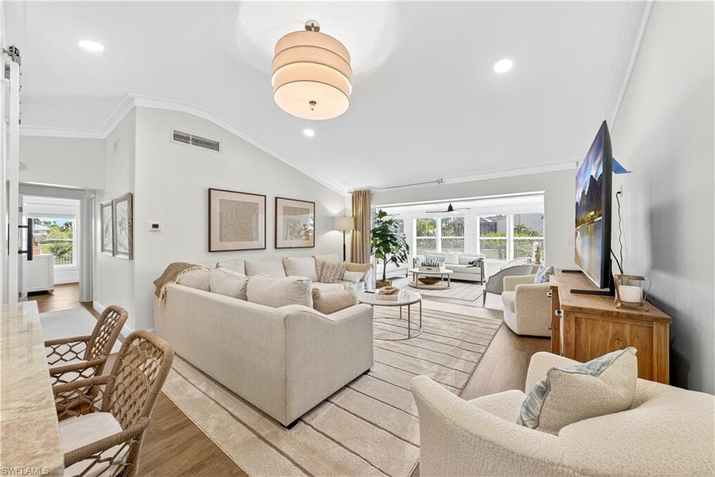 Spacious living area featuring high vaulted ceilings, recessed lighting, and wood-finish flooring
