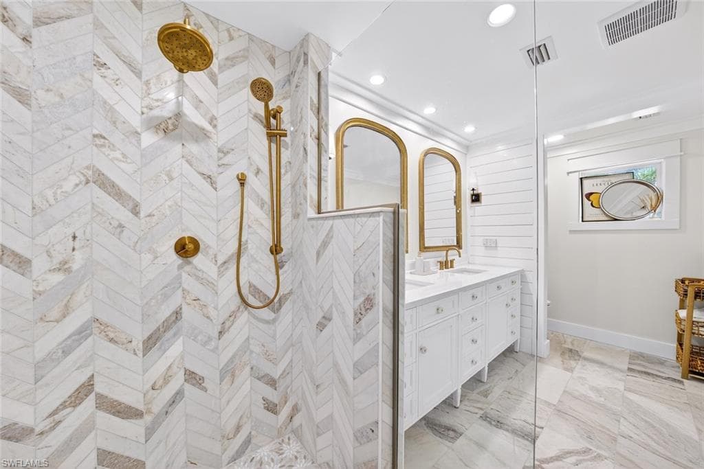 Shower with chevron-patterned tile work and brass fixtures