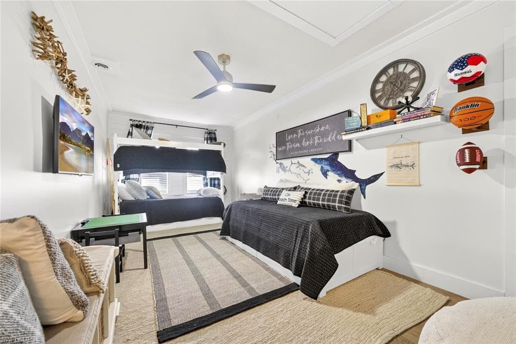 Spacious room featuring a bunk bed, a single bed frame, a ceiling fan, a wall-mounted television, and crown molding