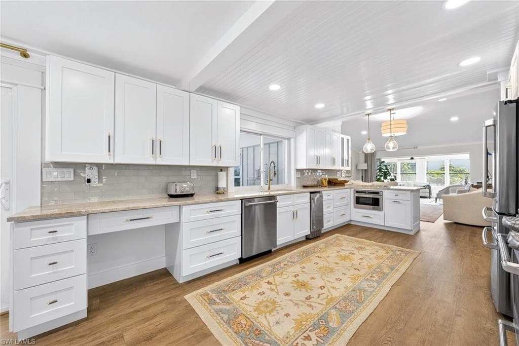 Modern kitchen featuring white cabinetry, stainless steel appliances, and light-toned countertops
