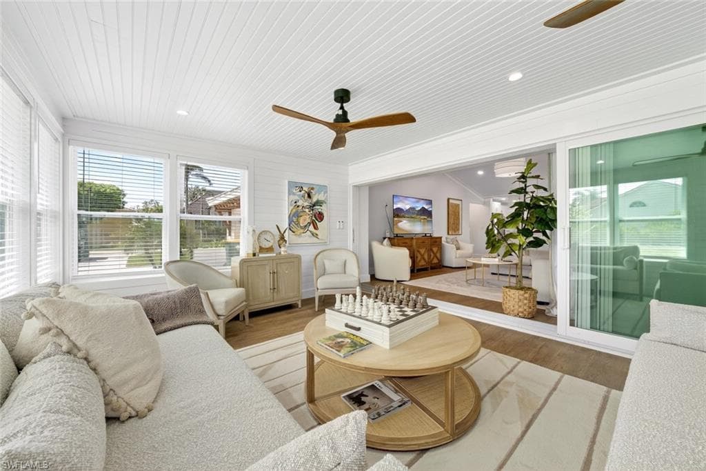 Bright sunroom with multiple windows and white blinds, featuring a tongue and groove ceiling, recessed lighting, and a ceiling fan