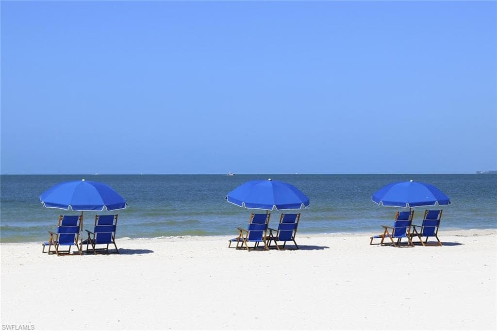 White sand beach with blue ocean waters and a clear sky backdrop - Virtually Edited Image