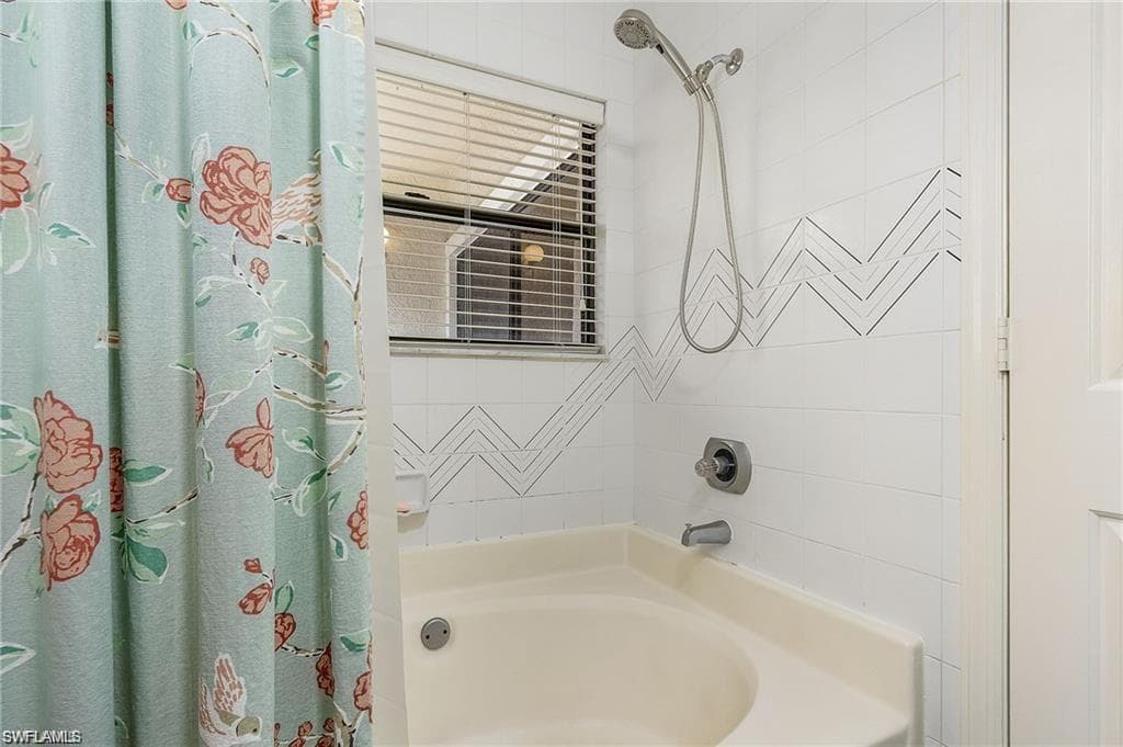 Bathroom with shower / bathtub combination with curtain