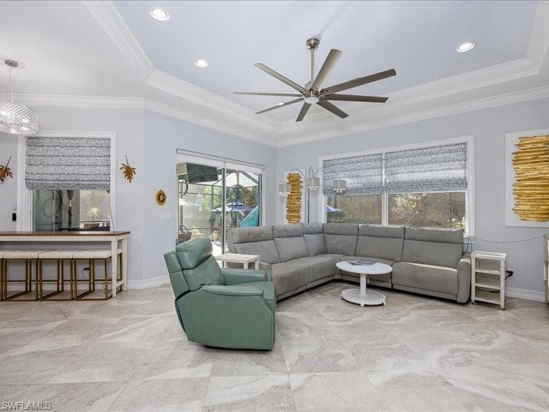 Spacious living area featuring large format tile flooring, crown molding, recessed lighting, and a modern ceiling fan