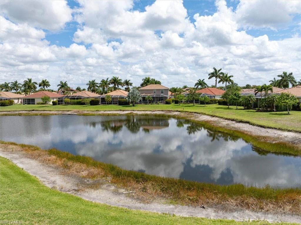 Close up view of lake and manicured green space behind the home.