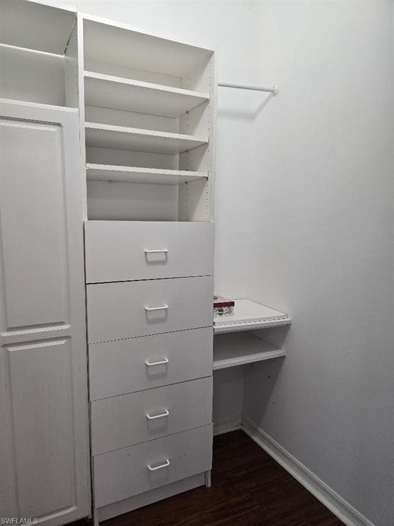 Custom closet system featuring open shelving, five built-in drawers with modern pulls, a dedicated hanging rod, and additional built-in shelving