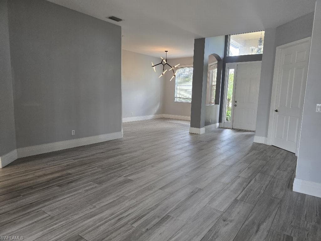 Spacious main living area featuring wood-finish flooring, neutral gray wall tones, and white baseboards