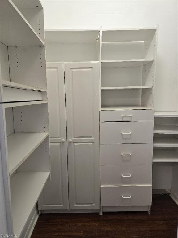 Custom closet system featuring white built-in shelving, drawers, and cabinetry
