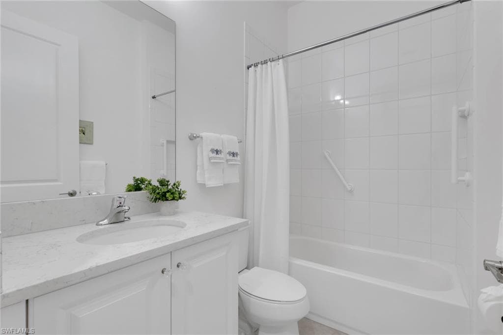 Modern bathroom featuring a single vanity with a light-colored countertop, an integrated sink, and white cabinetry
