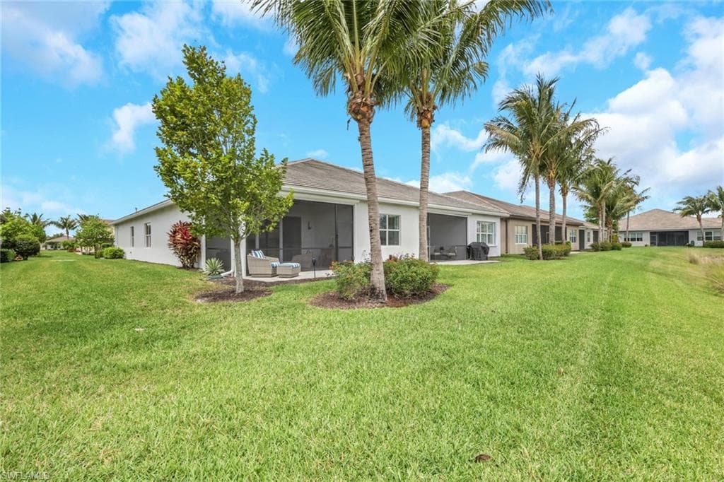 Expansive green lawn with mature palm trees and low-maintenance landscaping