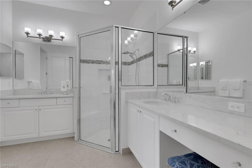 Dual vanity with undermount sinks, white cabinetry, and light-toned countertops