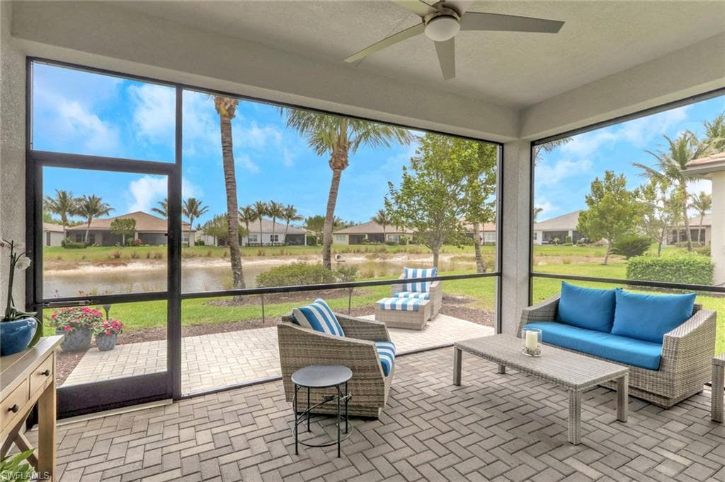 Screened lanai featuring paver flooring and a ceiling fan