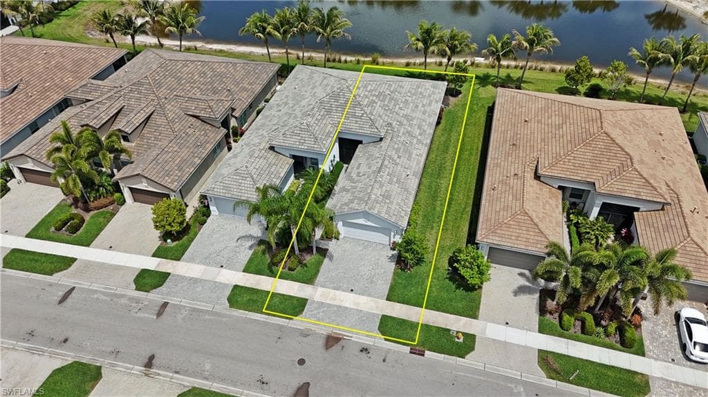 Single-story residence featuring a tile roof, paved driveway, and established landscaping