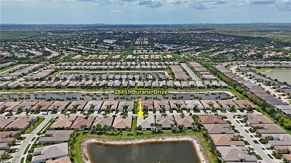 Aerial perspective showcasing a residential community with numerous properties featuring tile roofs and paved driveways