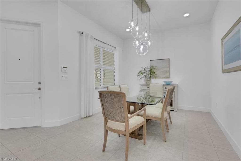 Dining space featuring tile flooring, a multi-globe pendant light fixture, recessed lighting, and a window with horizontal blinds and white curtains
