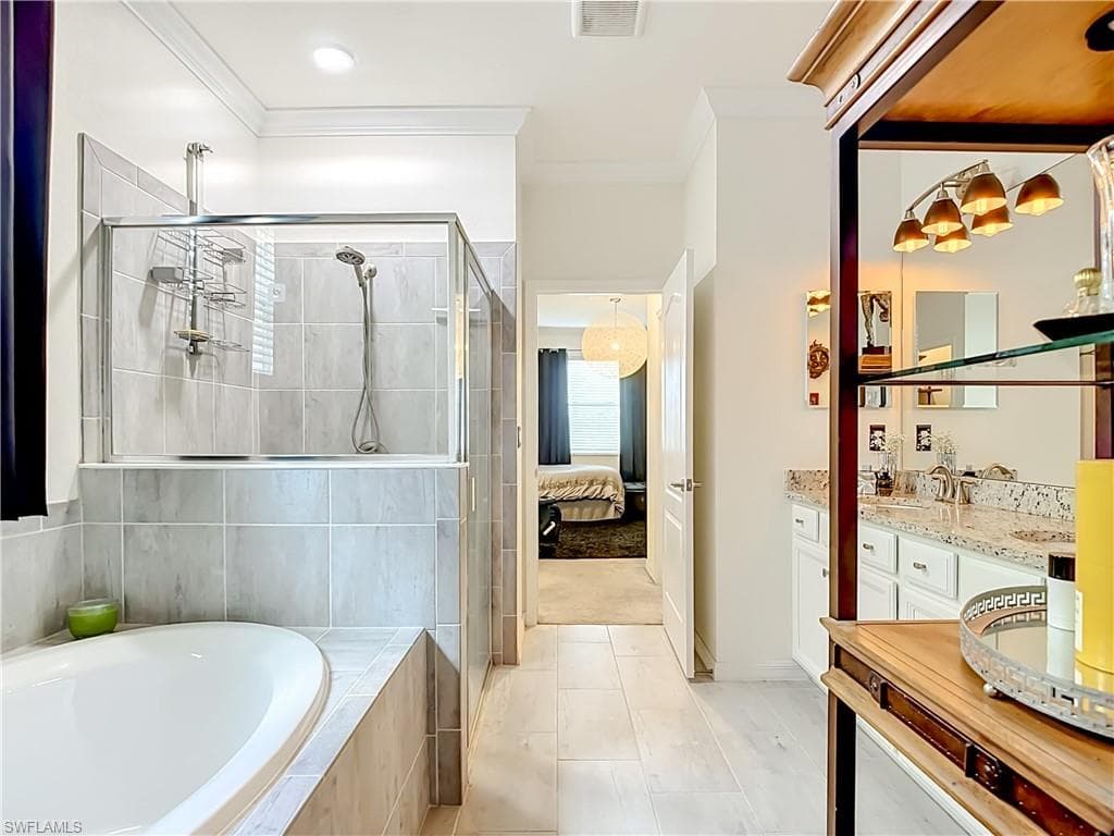 Bathroom featuring a built-in soaking tub and a glass-enclosed shower with tiled walls