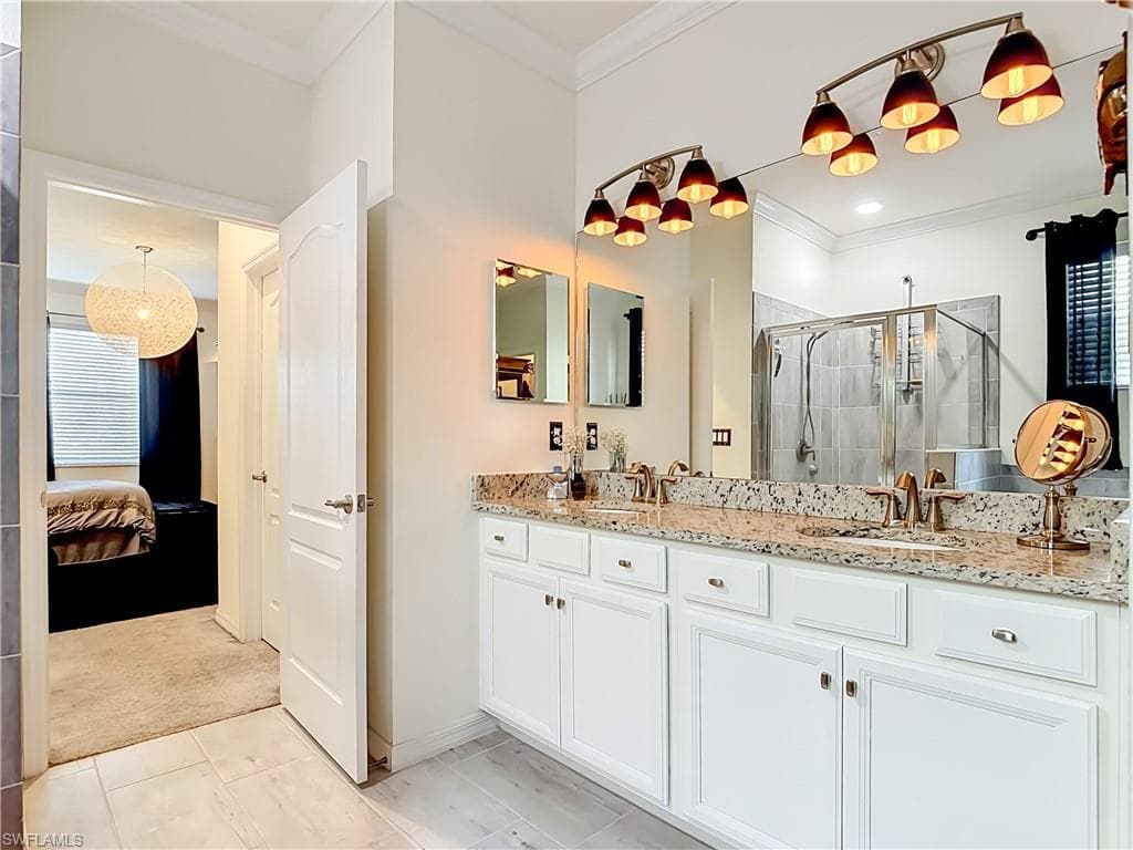 Bathroom featuring a dual vanity with a speckled countertop, undermount sinks, and brushed nickel hardware