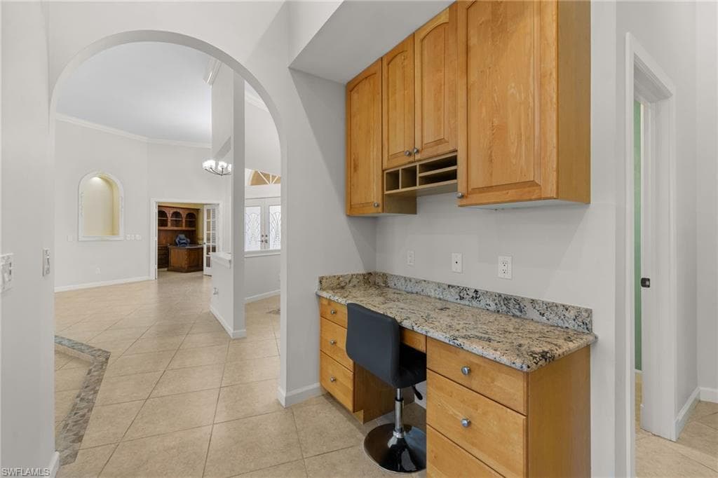 Kitchen featuring granite countertops, wood cabinetry, and a double basin sink
