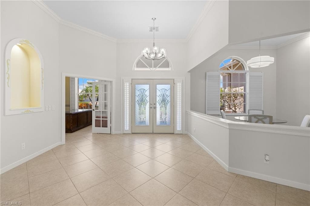 Stucco exterior featuring a prominent entryway with double glass doors