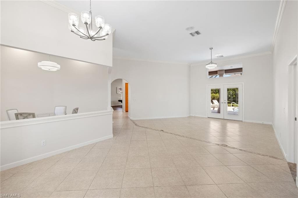 Spacious entryway featuring double-door entry with decorative glass, an arched transom window, and tile flooring