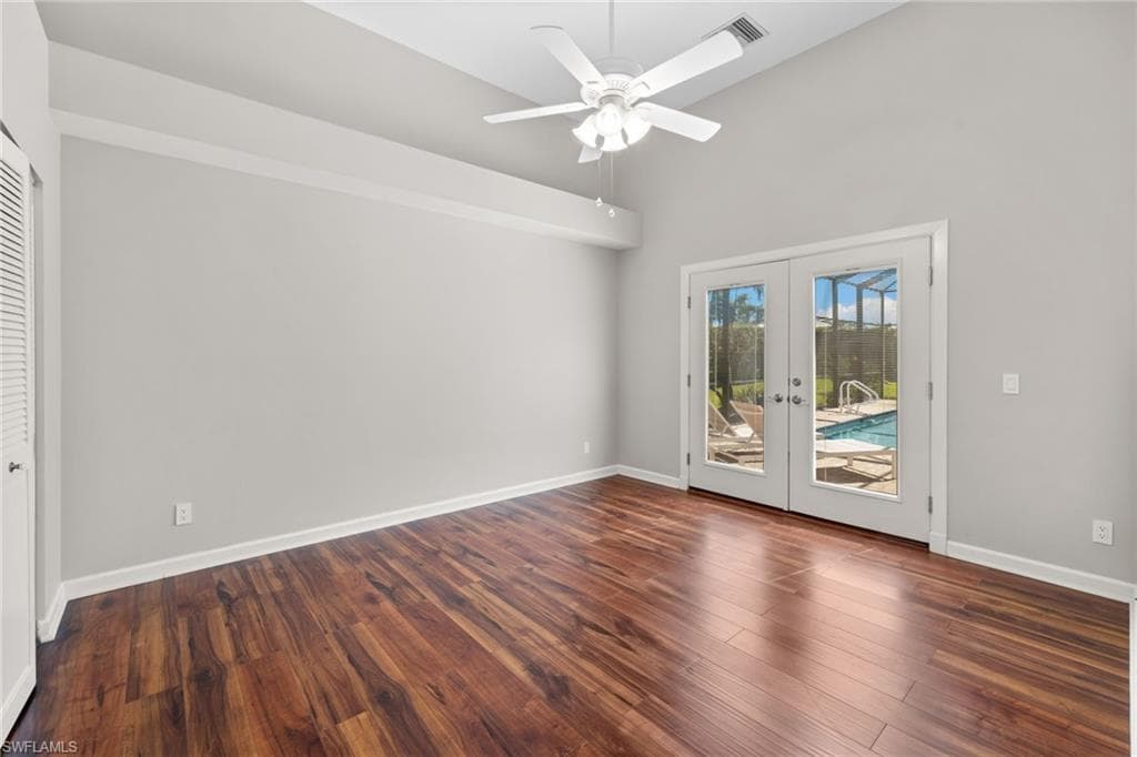 Bedroom #2, featuring bright interior space, window with louvered shutters, wood-finish flooring, and a ceiling fan