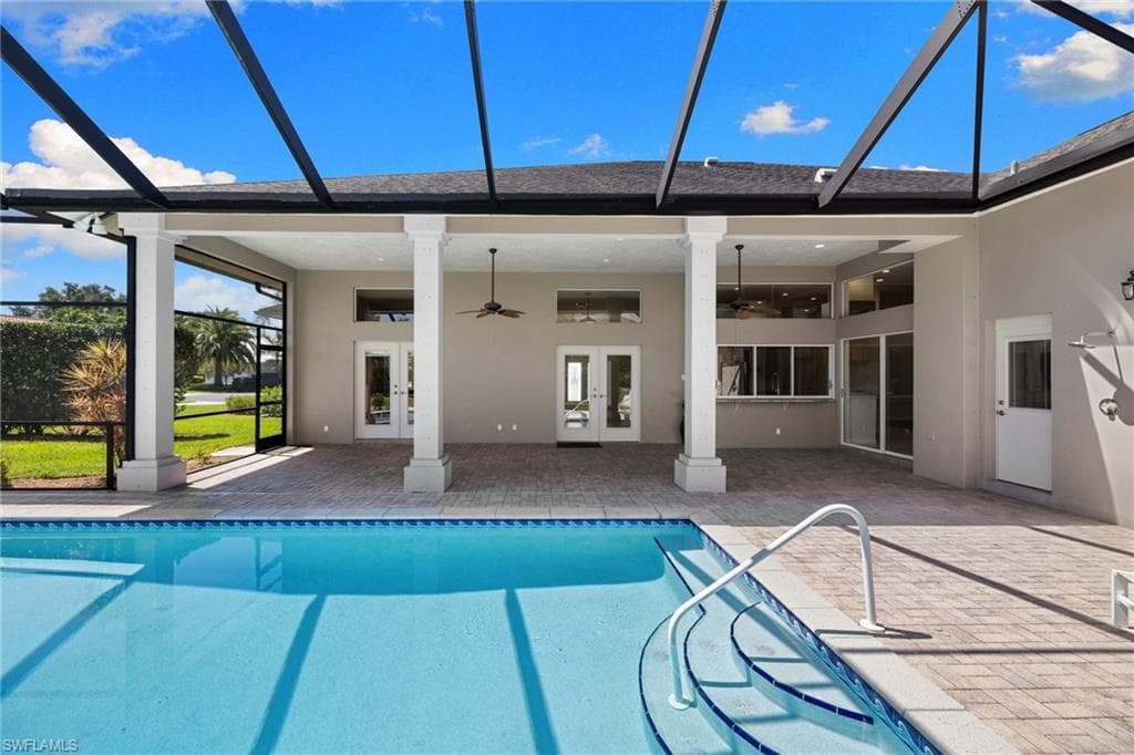 Screened-in outdoor pool area featuring a rectangular swimming pool with integrated steps, a paver patio, multiple entry points to the interior, and a ceiling fan on the covered lanai