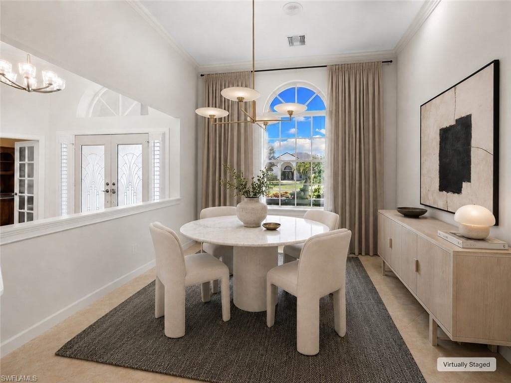 Spacious interior featuring neutral tile flooring, high vaulted ceilings, and crown molding