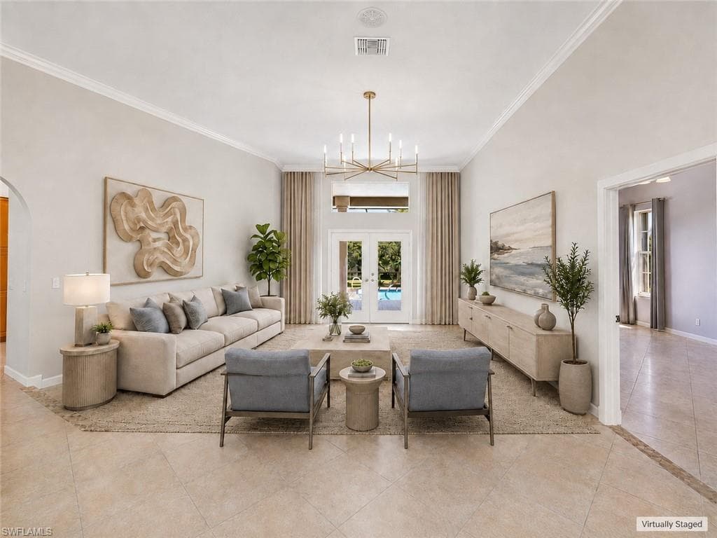Grand entry foyer featuring double doors with decorative glass panels, an arched transom window, and a high vaulted ceiling