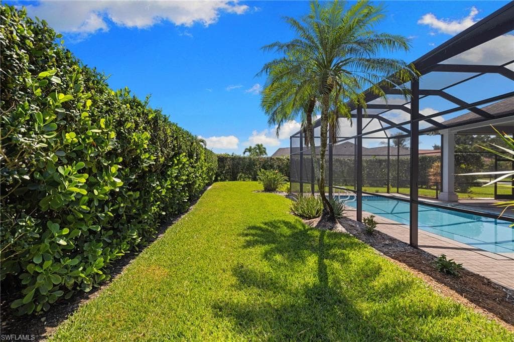 Expansive lawn area bordered by a tall, manicured hedge