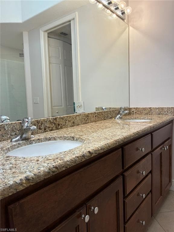Double vanity featuring a light-toned speckled countertop, integrated sinks, and dark wood-finish cabinetry with silver-tone hardware