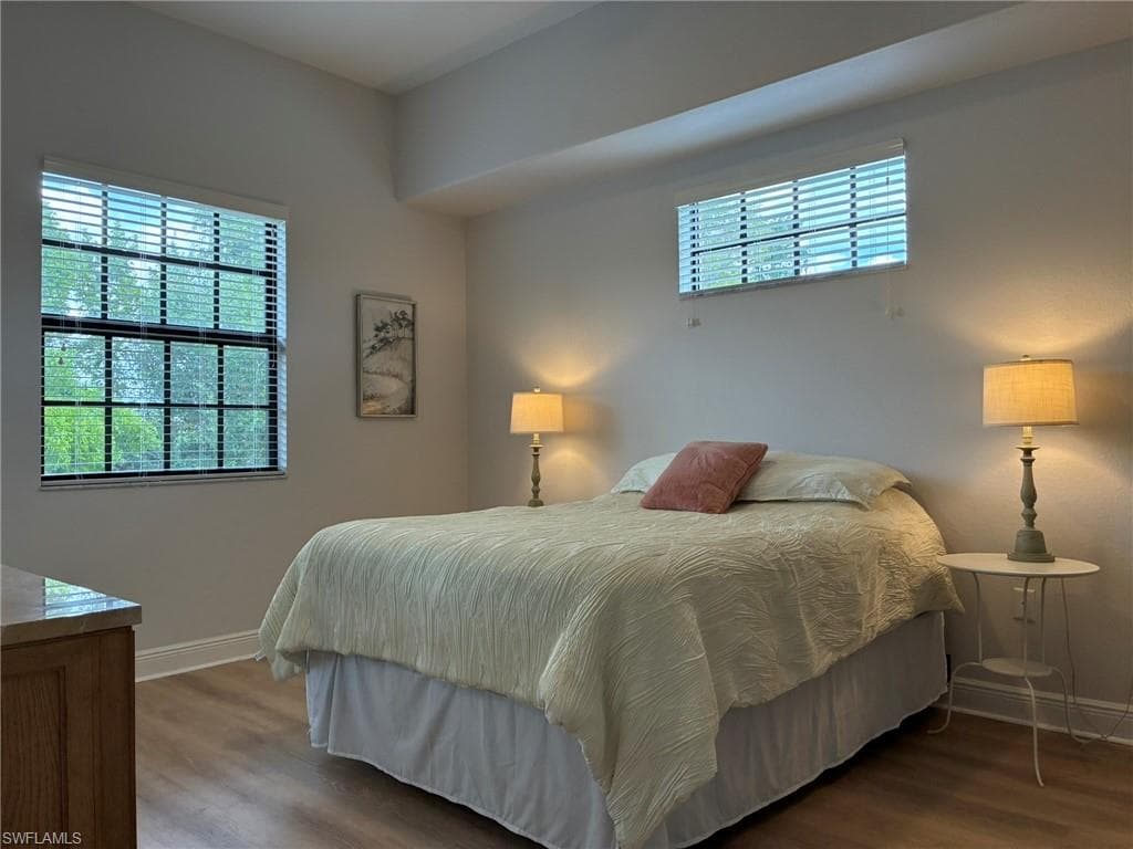 Bright interior featuring light-toned walls, wood-finish flooring, and white baseboards