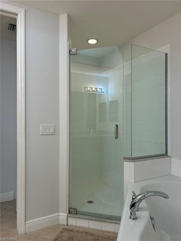 Glass-enclosed shower featuring white subway tile, recessed lighting, and a chrome shower handle