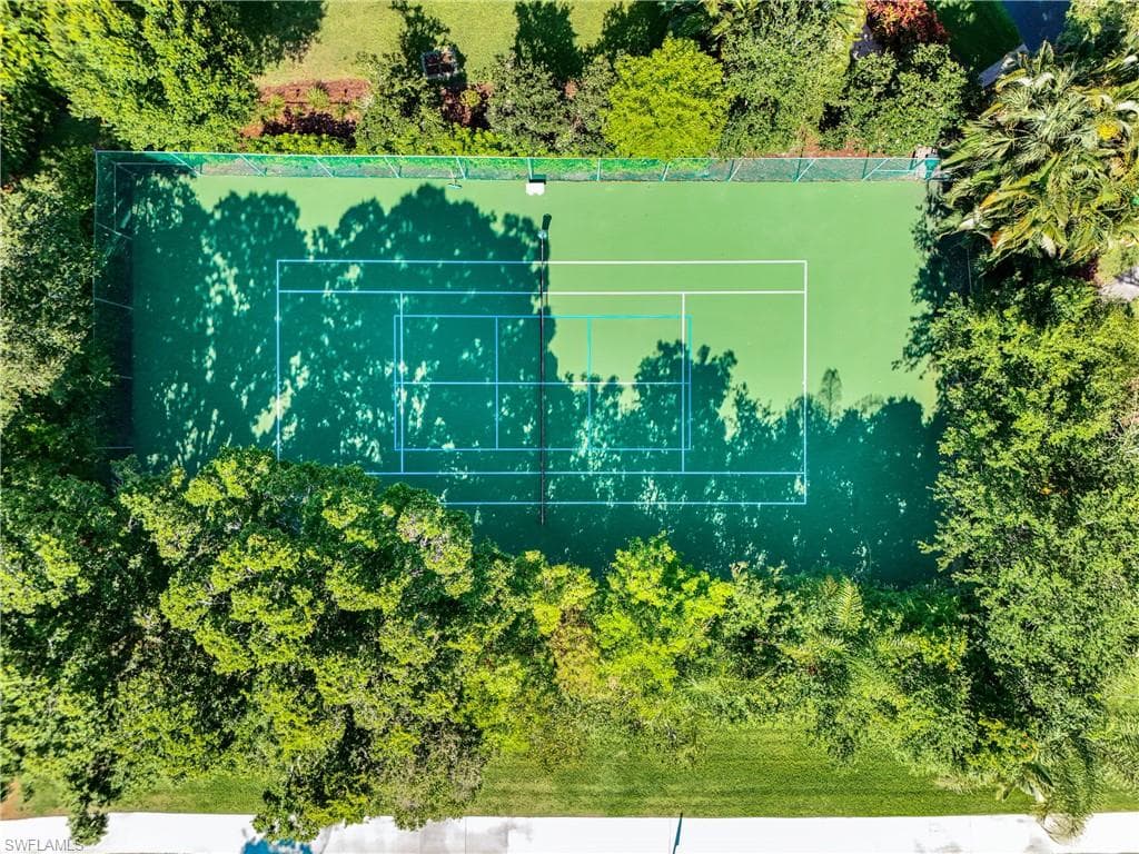 Private tennis court within the Hyde Park community surrounded by lush tropical landscaping.