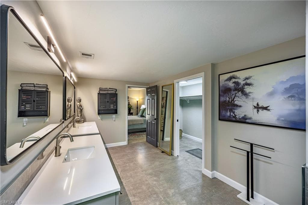 Modern primary bathroom showcasing a dual-sink vanity with white countertops and brushed nickel finishes.