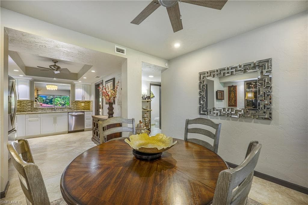 Open-concept dining area featuring tile flooring and a ceiling fan