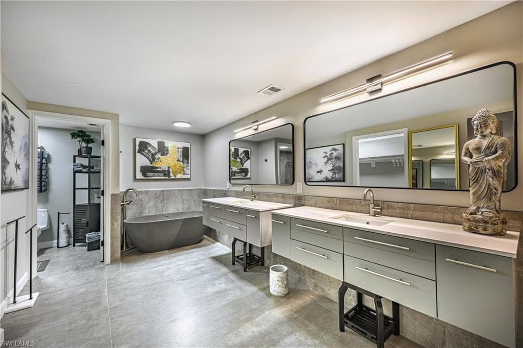 Beautifully designed primary bathroom with dual-sink vanities, sleek finishes, and a freestanding bathtub.