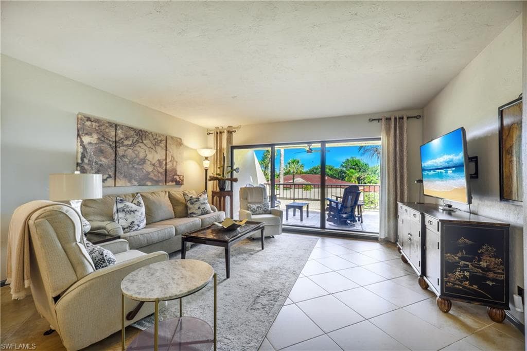 Spacious living area featuring large format tile flooring and direct access to an outdoor balcony