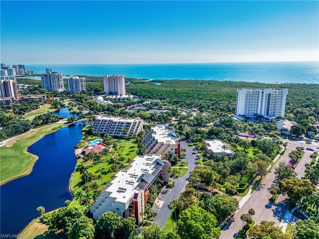 Aerial perspective showcasing Hyde Park nestled between scenic lakes, golf course greenery, and the Gulf coastline.
