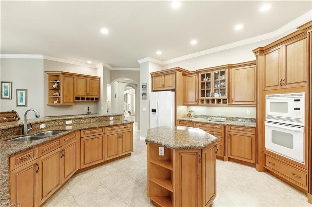 Spacious kitchen featuring extensive wood cabinetry, granite countertops, and tile flooring