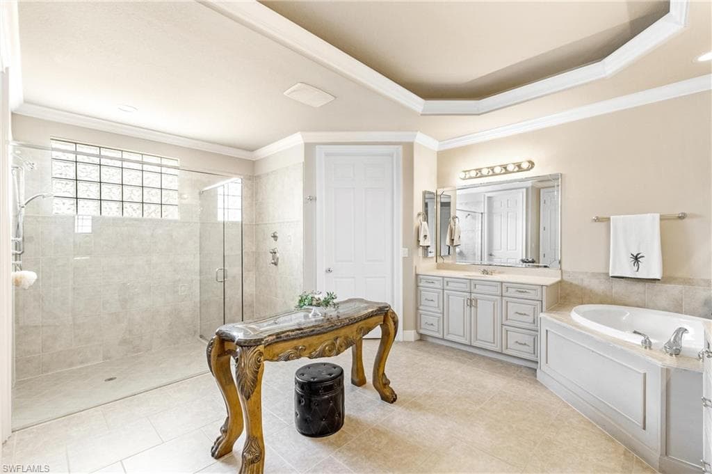 Neutral-toned bathroom featuring a spacious glass-enclosed shower with tile walls and a glass block window, a built-in soaking tub with paneled surround, and a dual-sink vanity with light-colored cabinetry and a large mirror