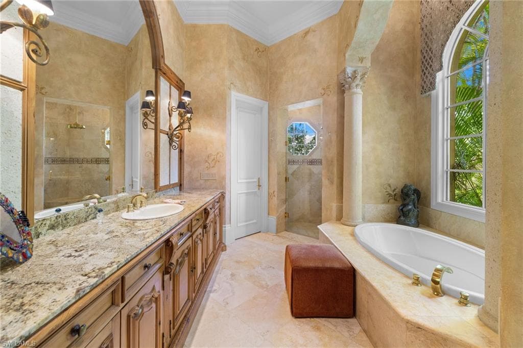 Double vanity featuring wood cabinetry and a stone countertop