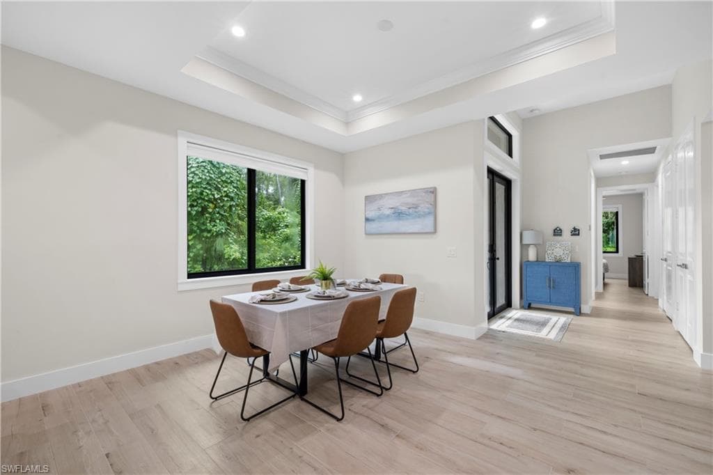 Dining area featuring a tray ceiling with recessed lighting