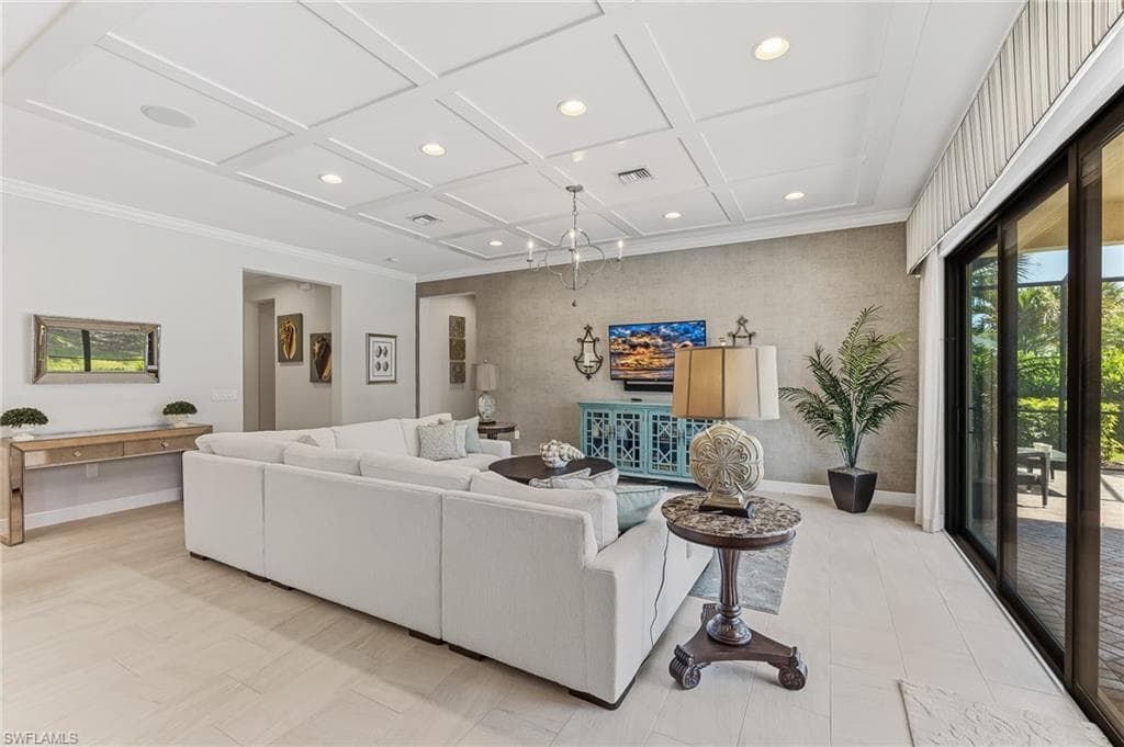 Living space featuring coffered ceilings with recessed lighting, light-toned tile flooring, and a textured accent wall