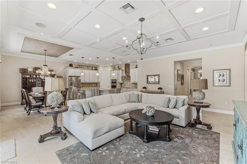 Open-concept living space featuring a coffered ceiling with recessed lighting and a decorative chandelier
