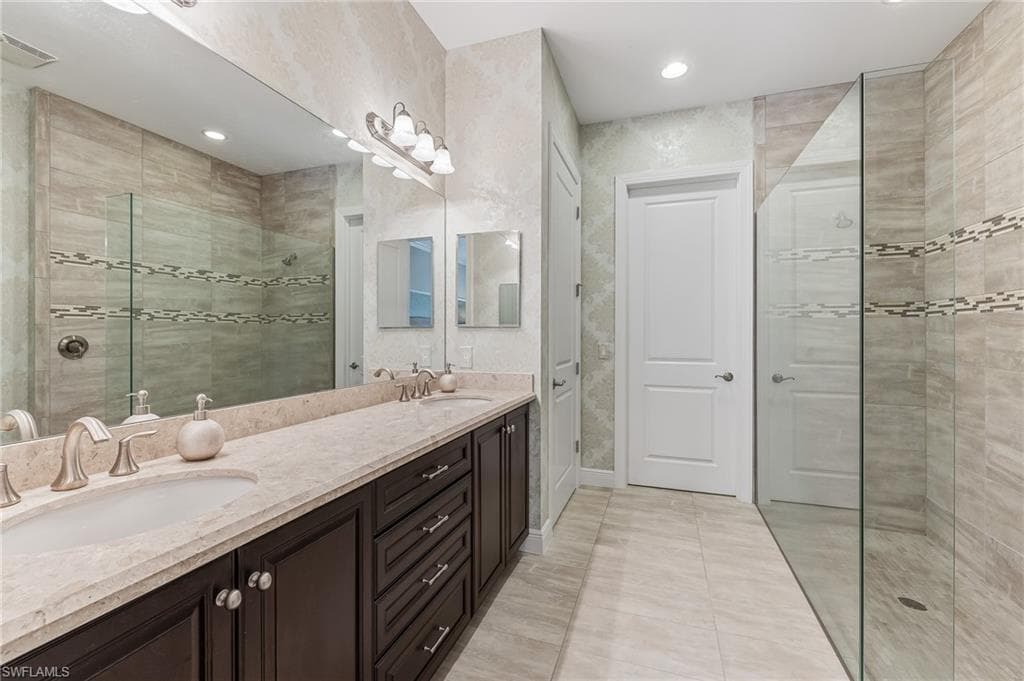 Dual vanity featuring a light-toned countertop, undermount sinks, and dark wood-finish cabinetry