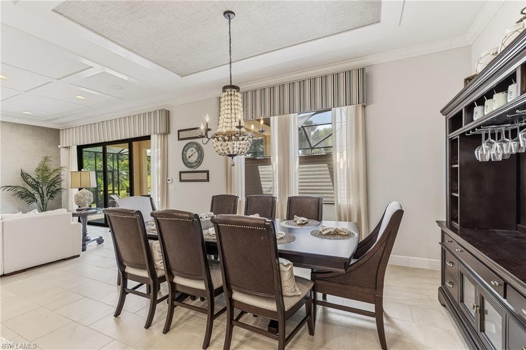 Formal dining space featuring a chandelier light fixture, recessed ceiling detail, and large format tile flooring