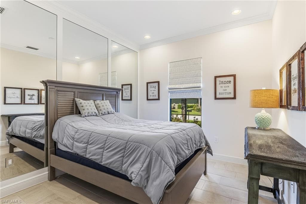Room featuring wood-finish flooring, a window with a roman shade, crown molding, and recessed lighting