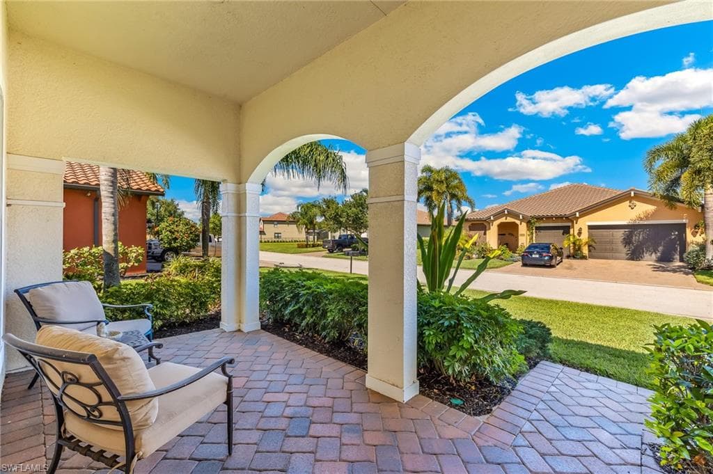 Covered entry with arched architectural details and brick paver flooring